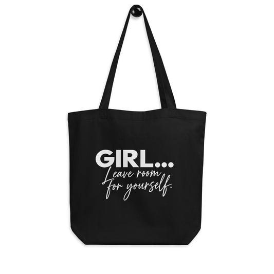 A black canvas tote bag with long shoulder straps, featuring the text 'GIRL...Leave room for yourself.'