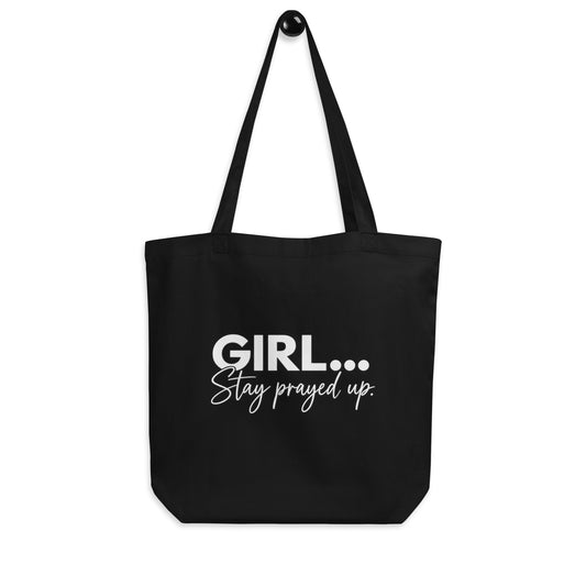 A black canvas tote bag with long shoulder straps, featuring the text 'GIRL...Stay prayed up.'